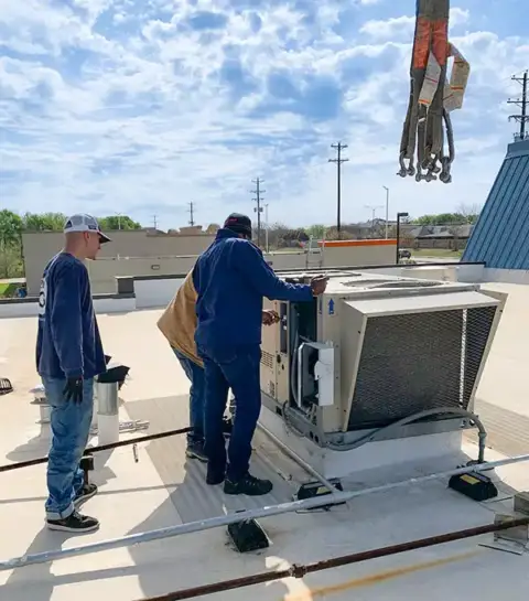 Air Zone Experts prepare to install a commercial air conditioner.