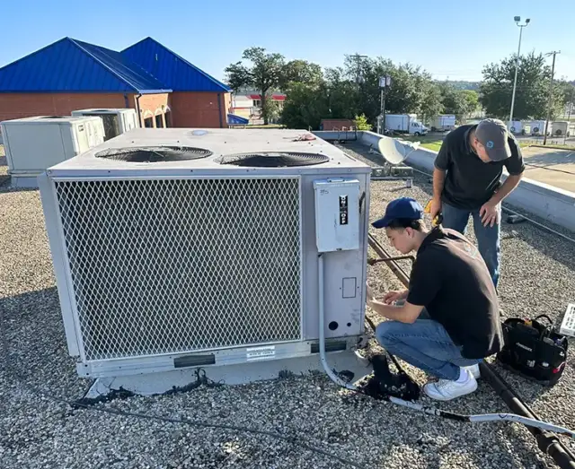 Two Air Zone Experts working on a commercial HVAC unit.
